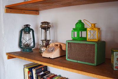 Rotary phone amidst vintage lanterns on shelf