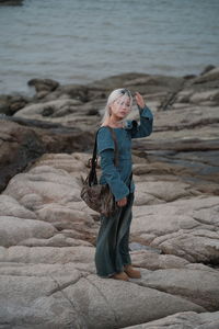Rear view of woman standing on rock