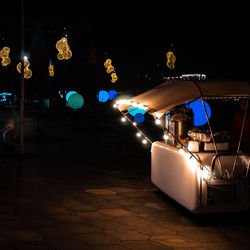 Illuminated carousel in city at night