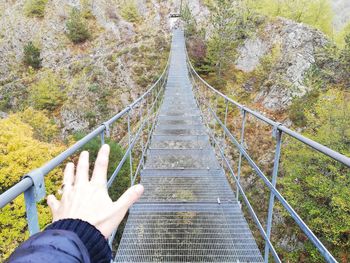 Low angle view of person on footbridge in forest