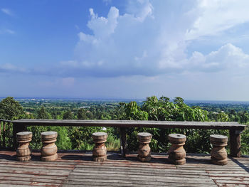 Cats on railing by sea against sky