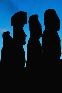 Low angle view of silhouette people against clear blue sky