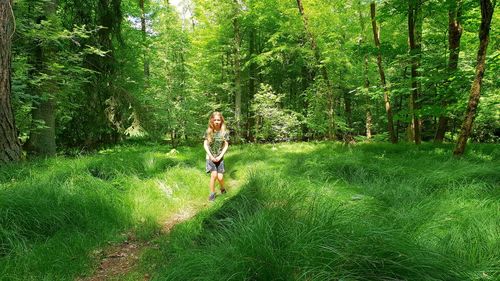 Full length of woman on tree in forest