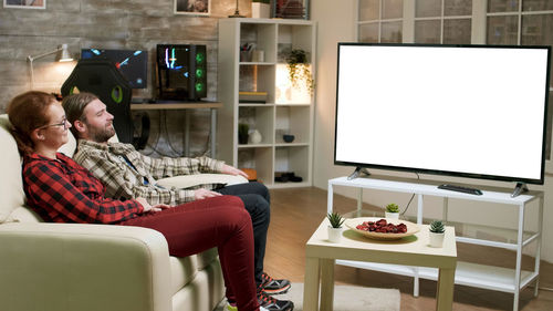 Young woman sitting on sofa at home