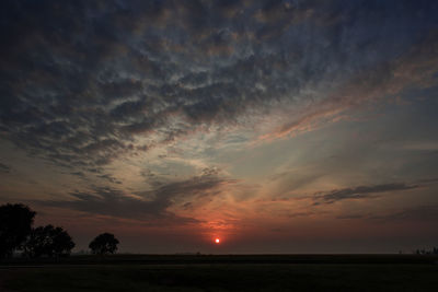 Scenic view of silhouette field against sky during sunset
