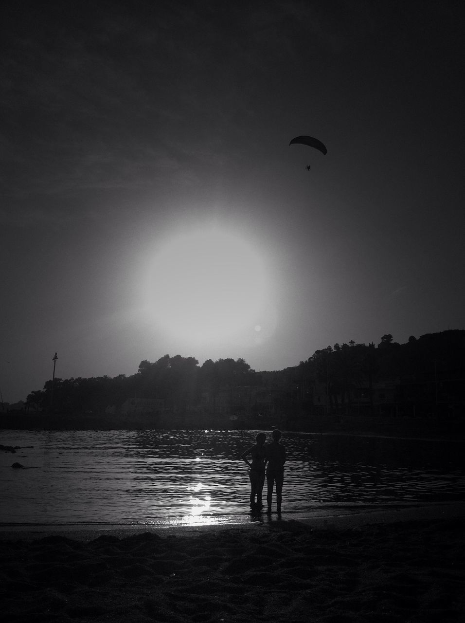 water, silhouette, leisure activity, lifestyles, sea, beach, men, sky, sun, scenics, tranquil scene, tranquility, nature, sunset, vacations, beauty in nature, shore, reflection