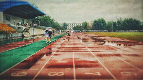 People walking on railing against sky