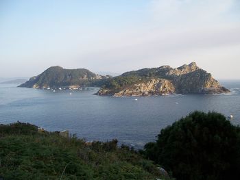Scenic view of sea and mountains against sky