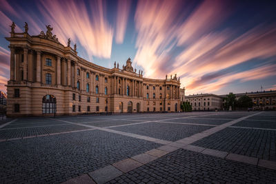 Buildings in city against sky at sunset