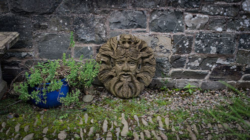 Low angle view of stone wall and sculpture