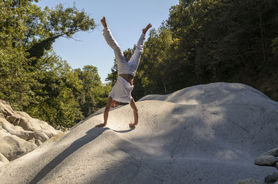 Full length of man jumping against trees