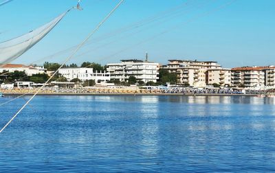 Scenic view of sea by buildings against blue sky