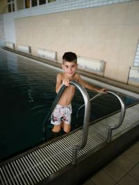 Shirtless boy standing in swimming pool