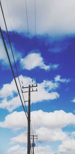 Low angle view of power lines against cloudy sky