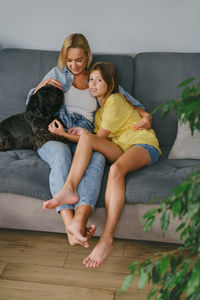 Portrait of young woman sitting on sofa at home