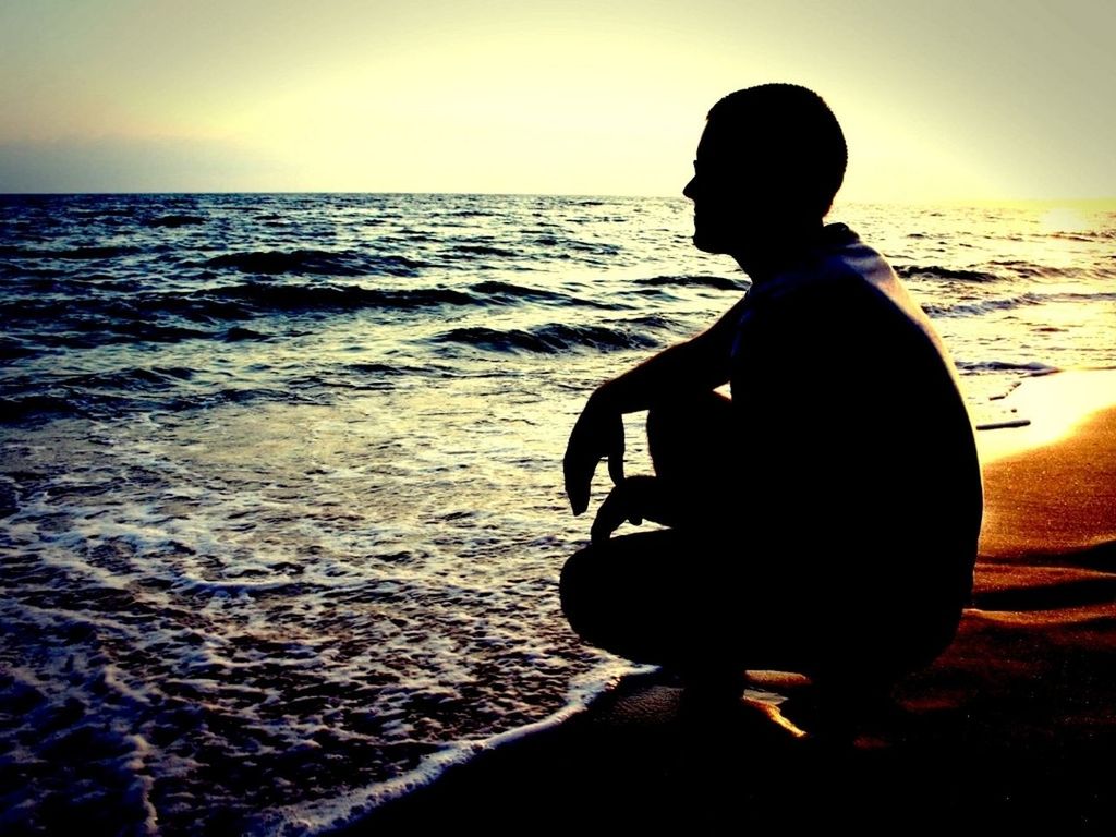 sea, horizon over water, water, sunset, beach, leisure activity, lifestyles, shore, sky, rear view, tranquility, scenics, tranquil scene, beauty in nature, silhouette, nature, sitting, standing