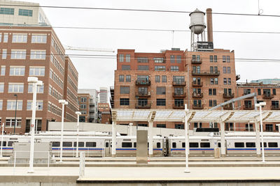 Lightrail train passing by apartment buildings at union station in denver, colorado