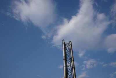 Low angle view of communications tower against blue sky