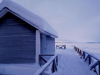 Gazebo by building against sky during winter