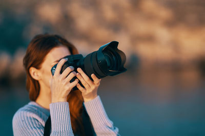 Midsection of woman photographing sea