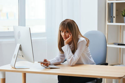 Young woman using laptop at table