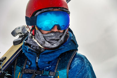 Closeup portrait of ski goggles of a man with reflection of snowy mountains. the mountain range is