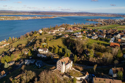 High angle view of townscape by sea against sky