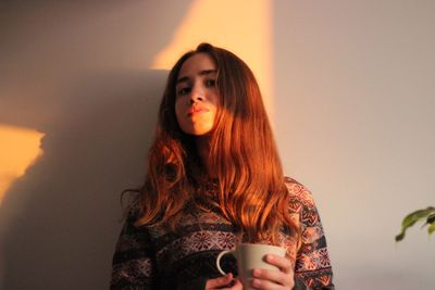 Portrait of young woman drinking coffee