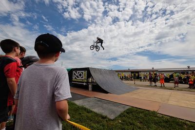 Rear view of people enjoying against sky