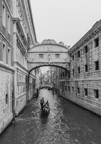 Arch bridge over canal against clear sky