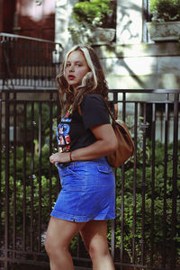 Portrait of beautiful woman standing against railing