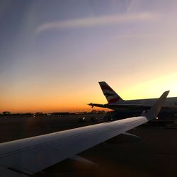 Airplane flying in sky at sunset