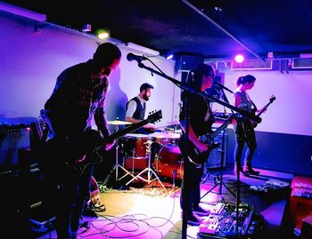 People playing guitar at music concert