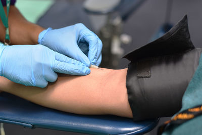 Midsection of doctor injecting needle to patient 