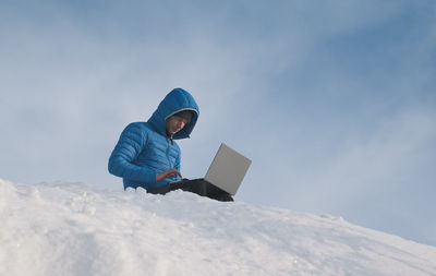The scientist uses a laptop on the top of the mountain. theme of climate change and ecology