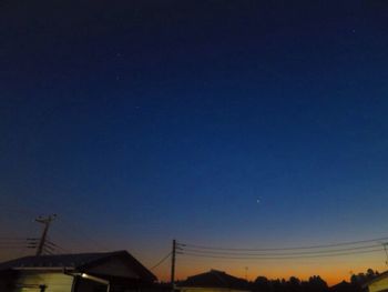 Silhouette built structure against clear blue sky at night