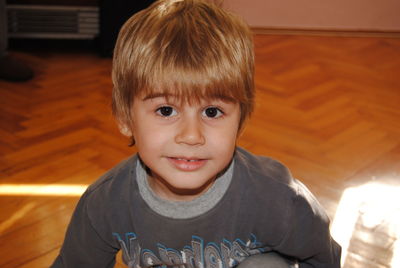 Portrait of cute boy on hardwood floor at home