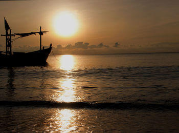 Silhouette ship in sea against sky during sunset