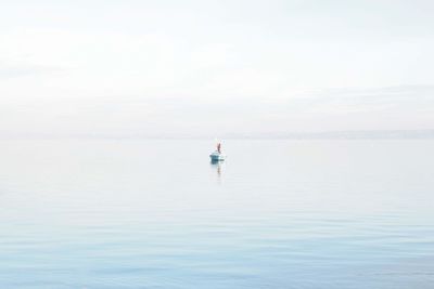 Rear view of man in sea against sky