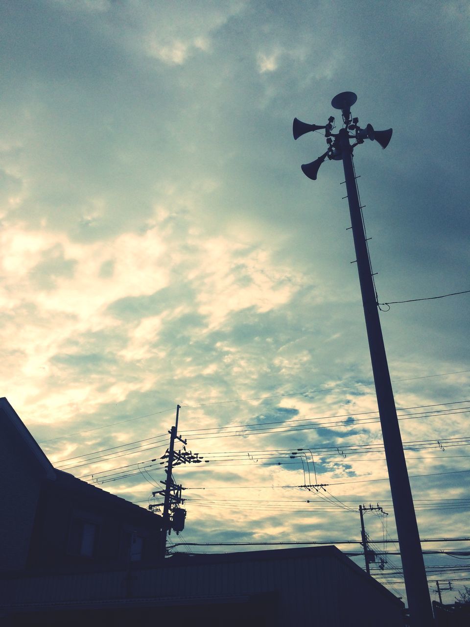 low angle view, sky, building exterior, architecture, built structure, cloud - sky, silhouette, cloudy, sunset, power line, street light, cloud, electricity, cable, high section, lighting equipment, electricity pylon, house, outdoors, technology