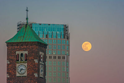 Low angle view of cross on building against sky at dusk