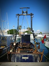 Ship moored at harbor against clear sky