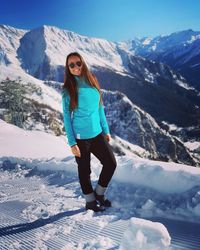Full length of woman standing on snowcapped mountain