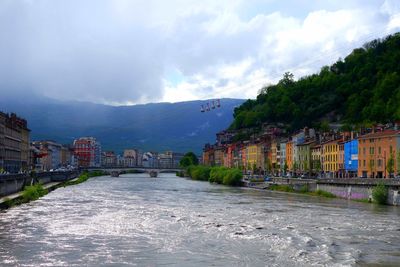 Road by buildings in city against sky