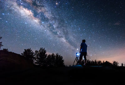 Silhouette man standing against star field