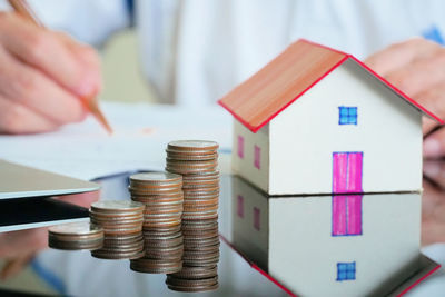 Cropped image of hand holding stack of objects on table