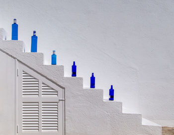 Blue bottles on steps of whitewashed building