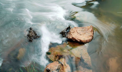 High angle view of waves breaking on rocks