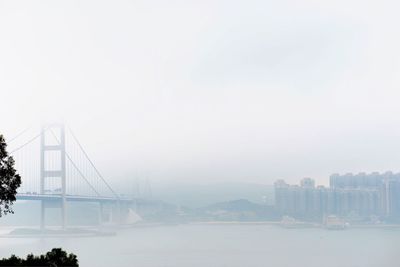 Bridge over sea against clear sky in foggy weather