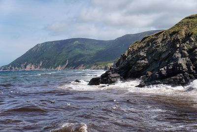 Scenic view of sea and mountains against sky